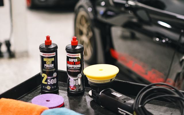 Detailing compounds, pads and a polisher laid out ready for a job
